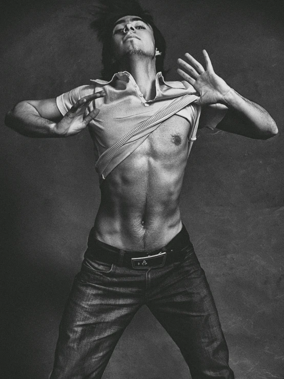 a black and white photo of a shirtless man, by Daniel Gelon, hyperrealism, playful pose of a dancer, jonny greenwood, wearing a shirt and a jean, dynamic action pose