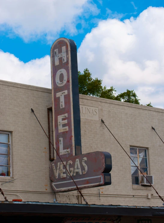 a motel sign on the side of a building, a photo, by Dan Luvisi, unsplash, art nouveau, bernie goes to vegas, 2 5 6 x 2 5 6 pixels, view from across the street, 1840s