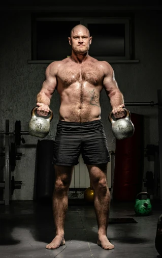a man holding two kettlebells in a gym, a portrait, by Steve Prescott, pexels contest winner, hairy chest, full body and head shot, high textured, made of flesh and muscles