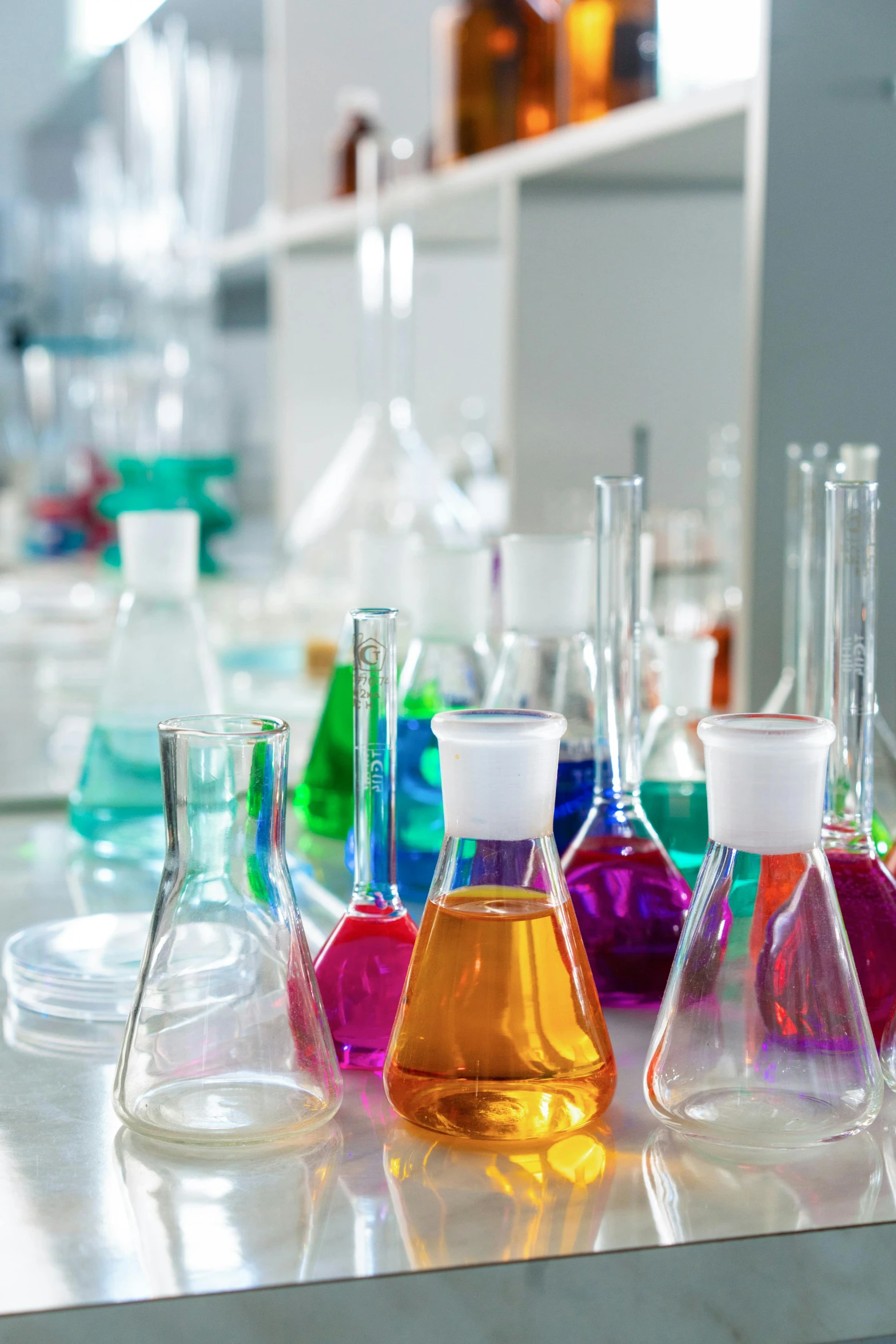 a group of laboratory flasks sitting on top of a counter, vibrantly colored, looking across the shoulder, industries, panels