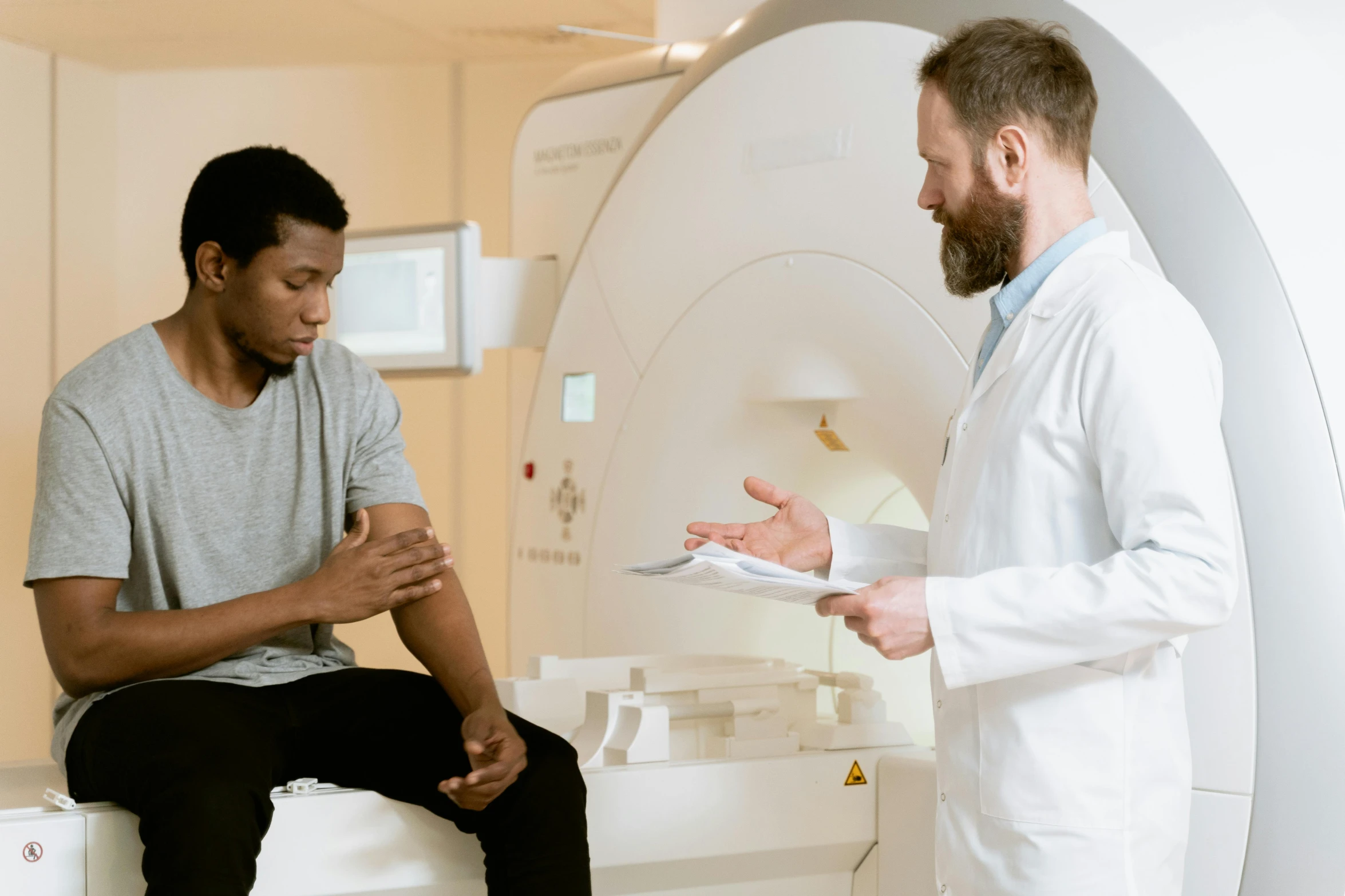 a man in a white lab coat talking to a man in a white lab coat, pexels contest winner, mri, brown, painful, low quality photo