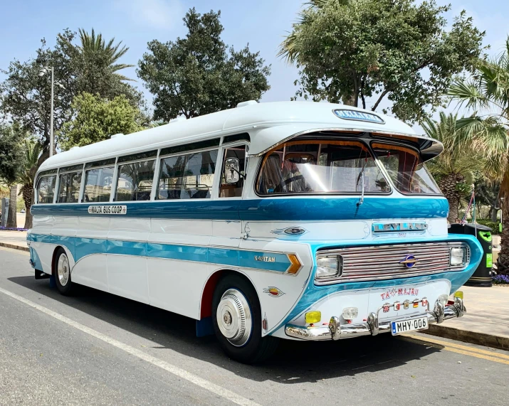 a blue and white bus driving down a street, cyprus, restomod, zig zag, magnificent design