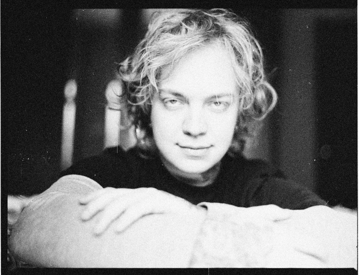 a black and white photo of a man with curly hair, a black and white photo, inspired by Lasar Segall, washed out color, paul giamatti, similar to malfoy, circa 1 9 9 9