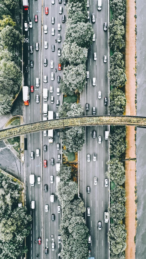 a highway filled with lots of traffic next to a forest, an album cover, inspired by Thomas Struth, unsplash contest winner, photorealism, north melbourne street, drone photograpghy, bridges, 🚿🗝📝