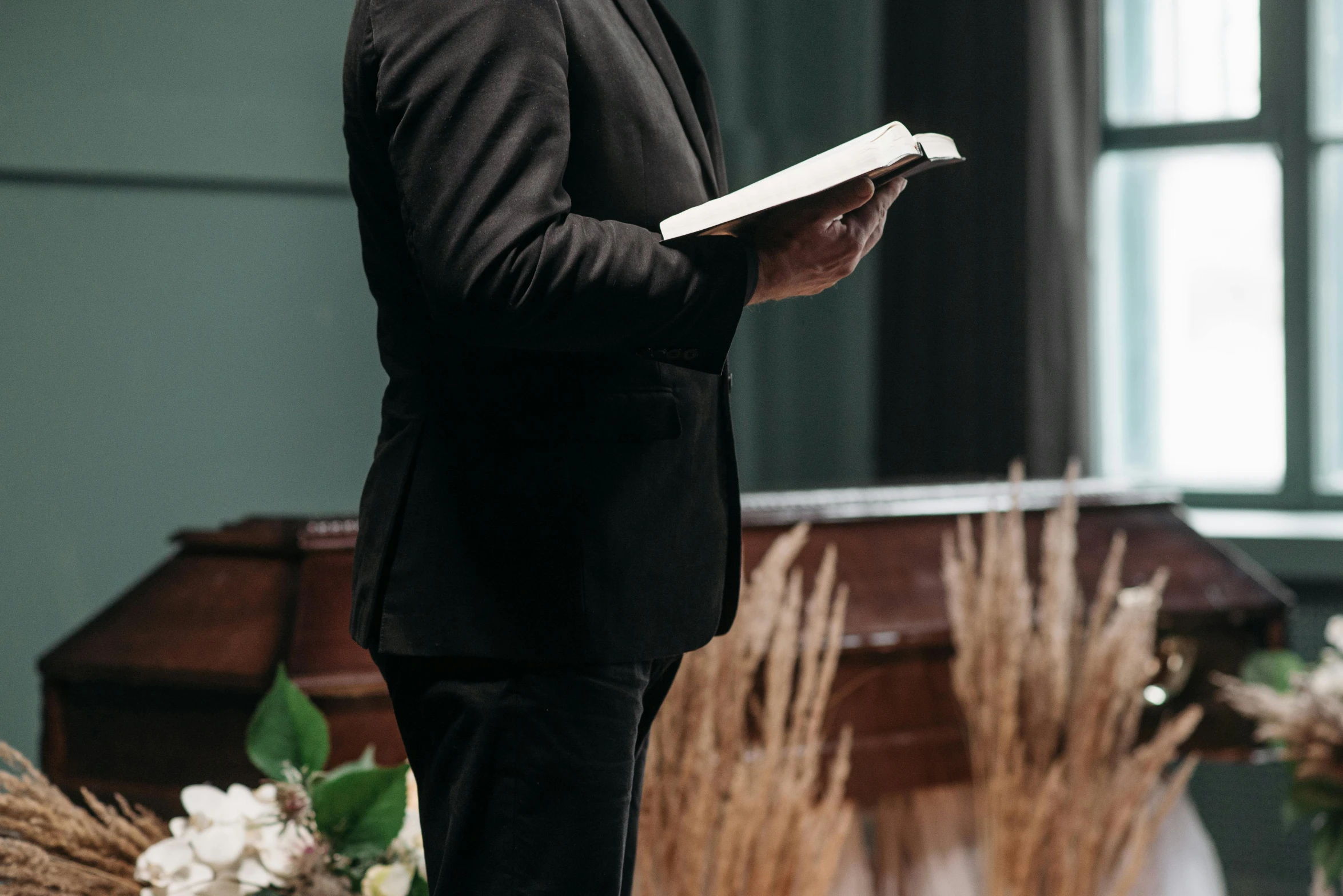 a man in a suit is reading a book, by Carey Morris, unsplash, renaissance, funeral, standing, royal commission, performing