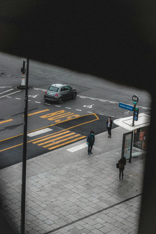 a couple of people walking across a street, a picture, pexels contest winner, intersection, black car, down there, discovered photo