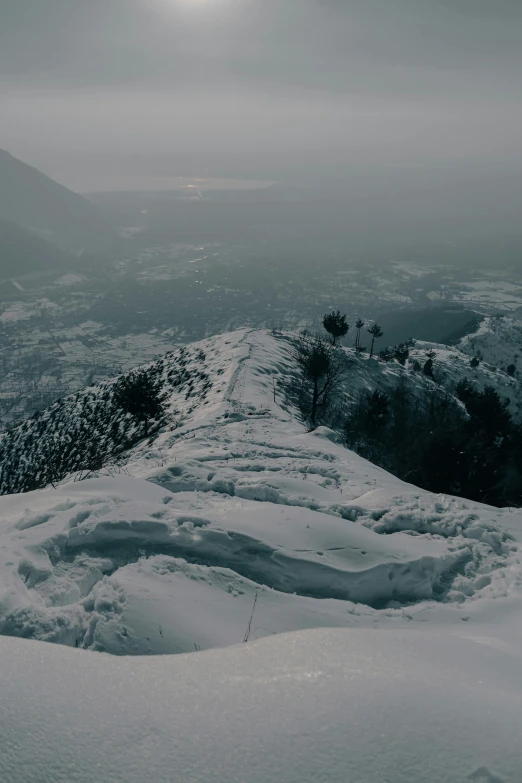 a person standing on top of a snow covered mountain, ominous! landscape of north bend, looking down, trending photo