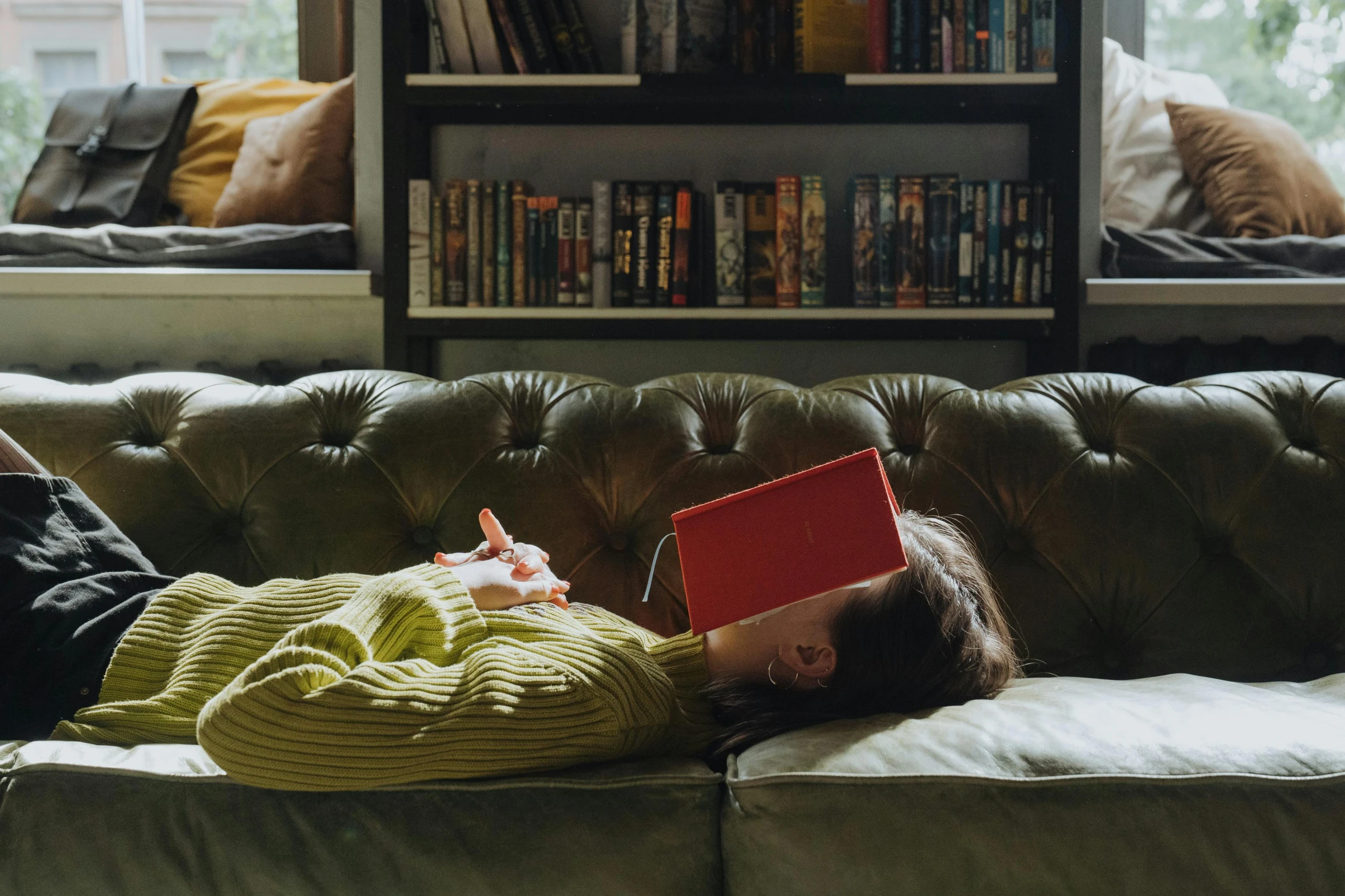 a person laying on a couch with a laptop, by Penelope Beaton, pexels contest winner, arts and crafts movement, liminal bookshop, olive green and venetian red, village girl reading a book, dwell