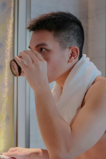 a man with a towel around his neck drinking from a cup, featured on reddit, non-binary, asian man, profile image, with shiny skin