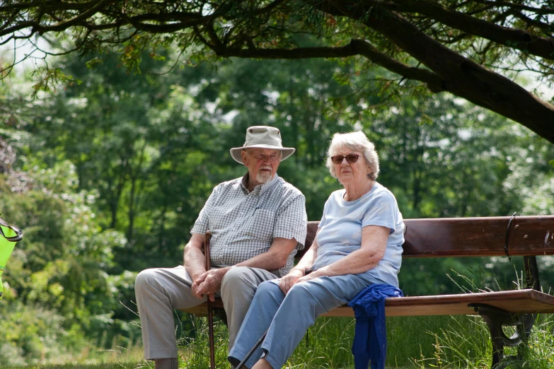 a man and a woman sitting on a park bench, profile image, elderly, sitting under a tree, environmental shot