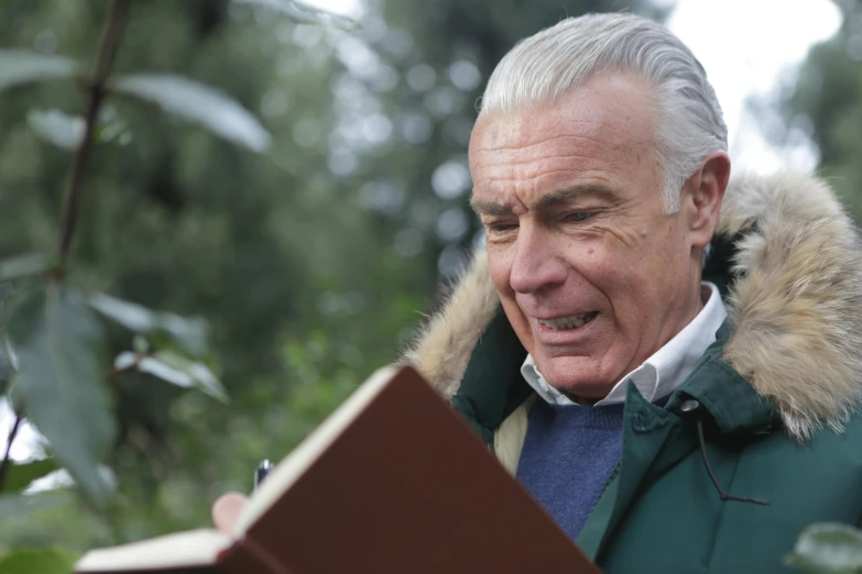 a man in a parka reading a book, inspired by Peter Maxwell Ewart, pexels contest winner, sean connery as gandalf, 15081959 21121991 01012000 4k, gardening, handsome man