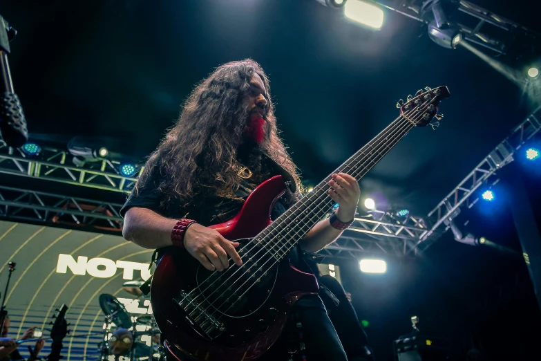 a man with long hair playing a bass, by Matt Cavotta, proto-metal concert, avatar image