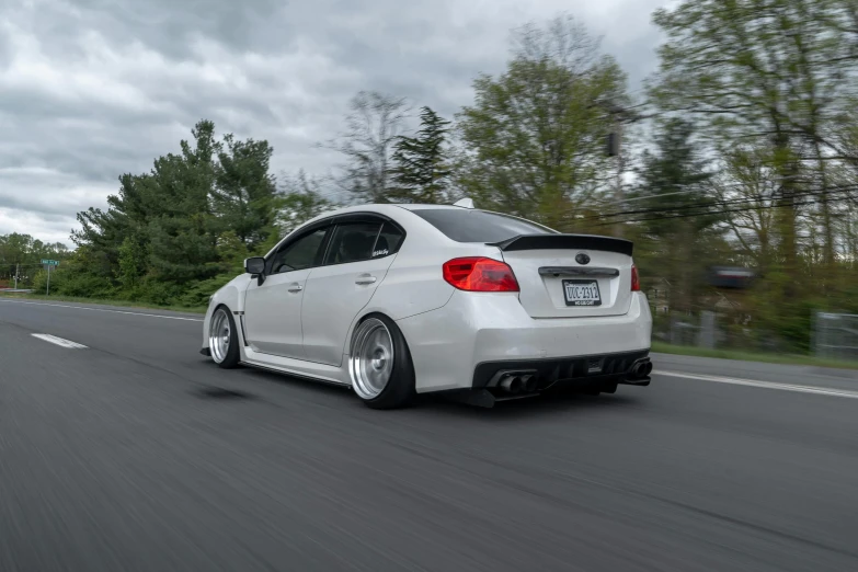 a white car driving down a road with trees in the background, inspired by An Gyeon, thicc build, profile shot, aaron earley, dipstick tail