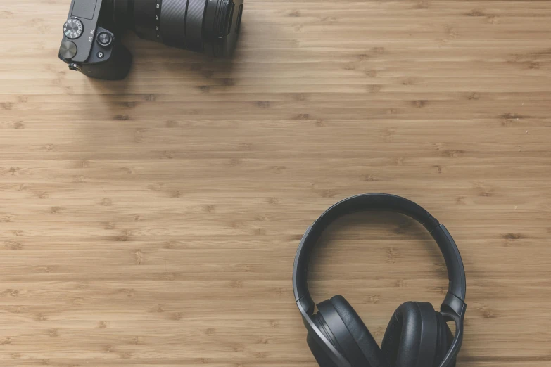 a pair of headphones sitting on top of a wooden floor, a picture, trending on pexels, background image, cameras lenses, aesthetic film grain, avatar image