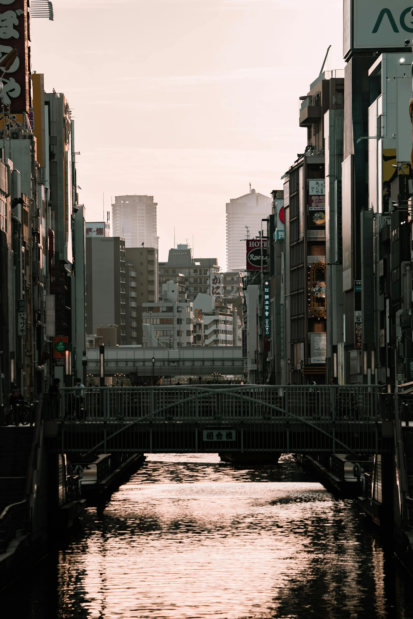 a river running through a city next to tall buildings, a picture, unsplash contest winner, ukiyo-e, brutalist city architecture, bridge city, 2022 photograph, japanese street