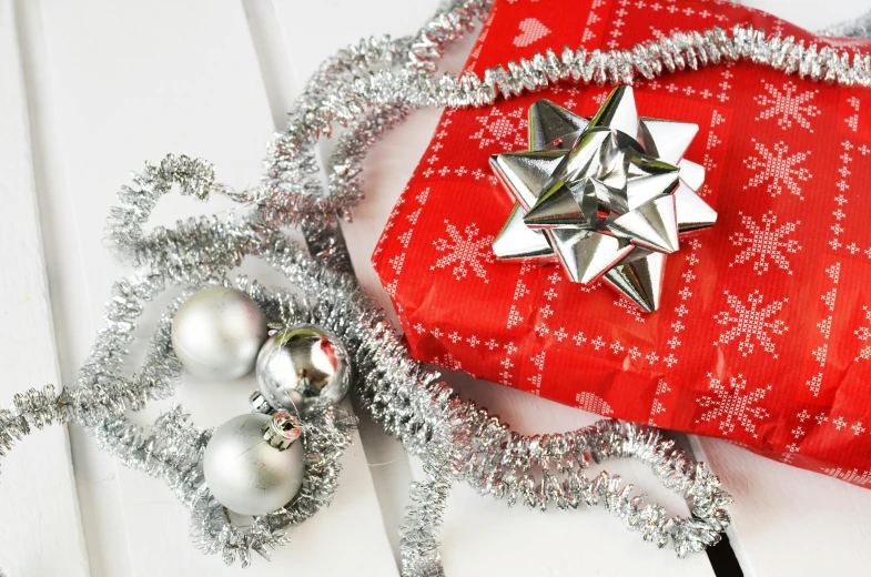 a red present sitting on top of a white table, by Georgina Hunt, pexels contest winner, glittering silver ornaments, high angle close up shot, 9 9 designs, thumbnail