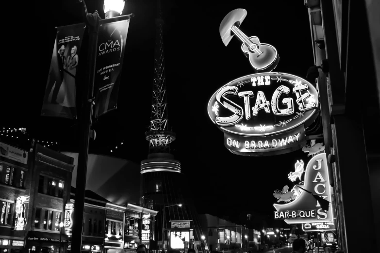 a black and white photo of a street at night, by Dan Frazier, pexels contest winner, gigantic neon signs, theatre stage, stratosphere, studio disney