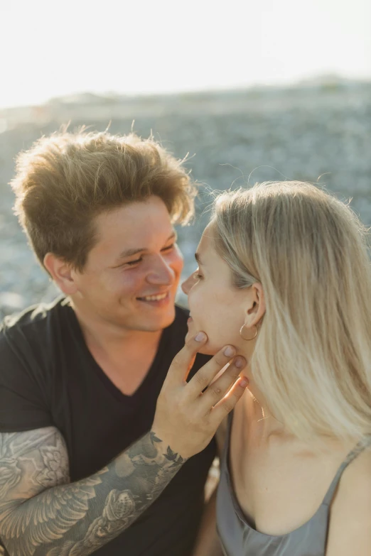 a man and woman sitting next to each other on a beach, pexels contest winner, renaissance, closeup headshot, flirting, tattooed, blonde man