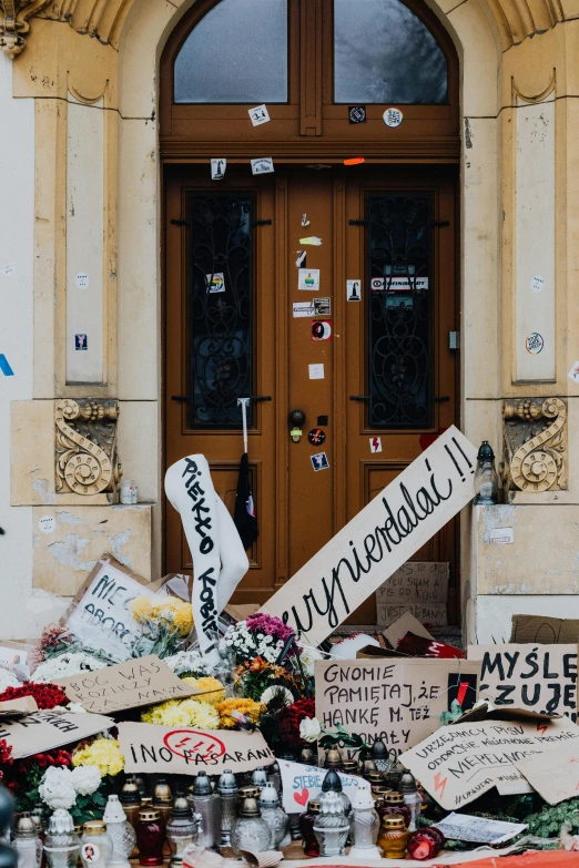 a bunch of signs sitting in front of a building, inspired by Mihály Munkácsy, tragedy, profile image, massive decorated doors, police tape