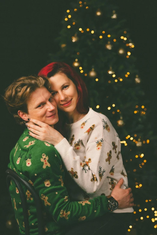 a man and woman hugging in front of a christmas tree, a portrait, by Julia Pishtar, pexels, androgynous person, 256435456k film, julian ope, portrait of two people