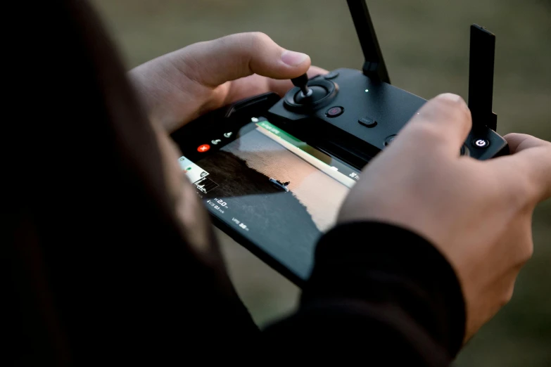 a close up of a person holding a game controller, unsplash, visual art, view from helicopter, graded with davinci resolve, using a magical tablet, hunting