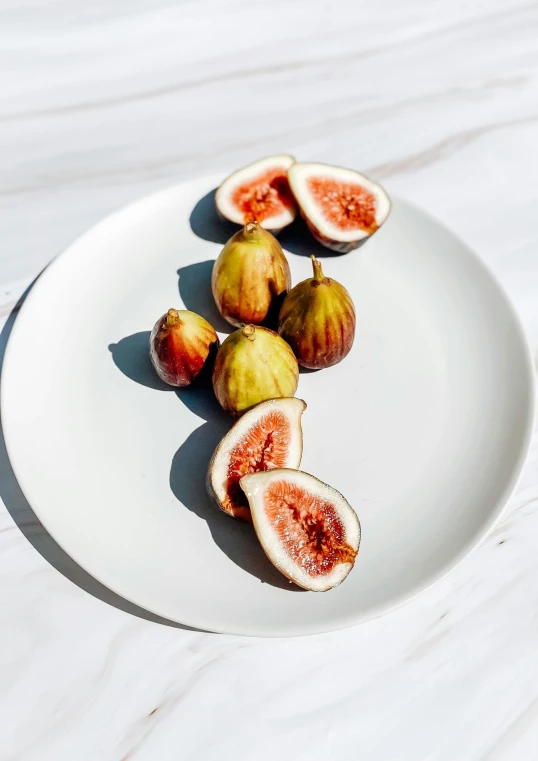 a white plate topped with figs on top of a table, 6 pack, bio-inspired, highly upvoted, crimson