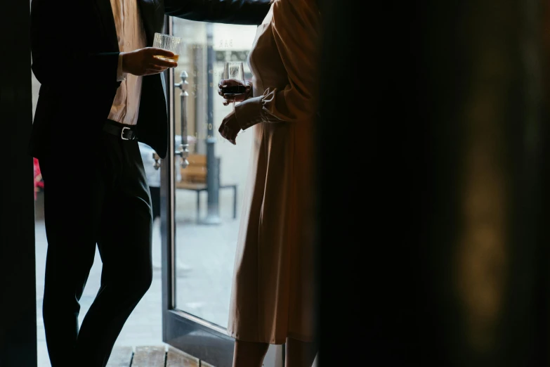 a man and a woman standing in front of a glass door, by Lee Loughridge, pexels contest winner, private press, scene from a dinner party, knees upturned, slightly minimal, reaching out to each other