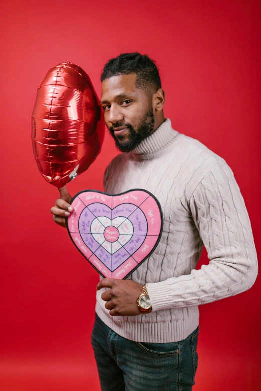 a man holding a heart shaped balloon in front of his face, a photo, pexels contest winner, pop art, ray lewis, mid-shot of a hunky, ap, holding gift