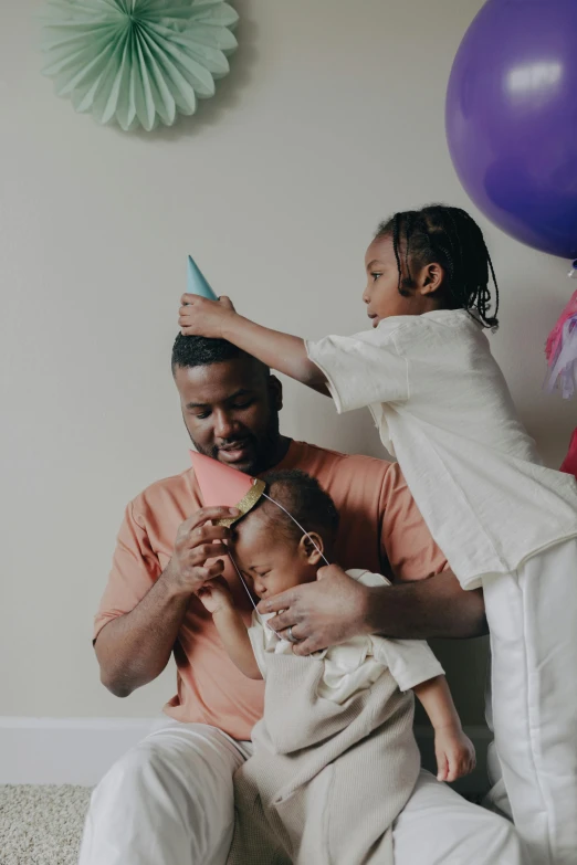 a man is combing a little girl's hair, pexels contest winner, party hats, portrait of kanye west, daddy/fatherly, celebrating a birthday