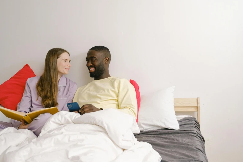 a man and woman reading a book on a bed, pexels contest winner, happening, smiling at each other, mkbhd, white bed, profile image