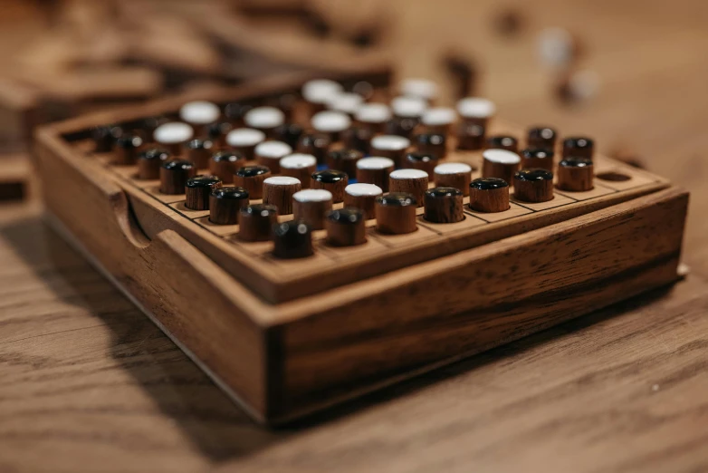 an old typewriter sitting on top of a wooden table, a jigsaw puzzle, by Daniel Lieske, unsplash, kinetic art, cups and balls, brown holes, close-up product photo, game case