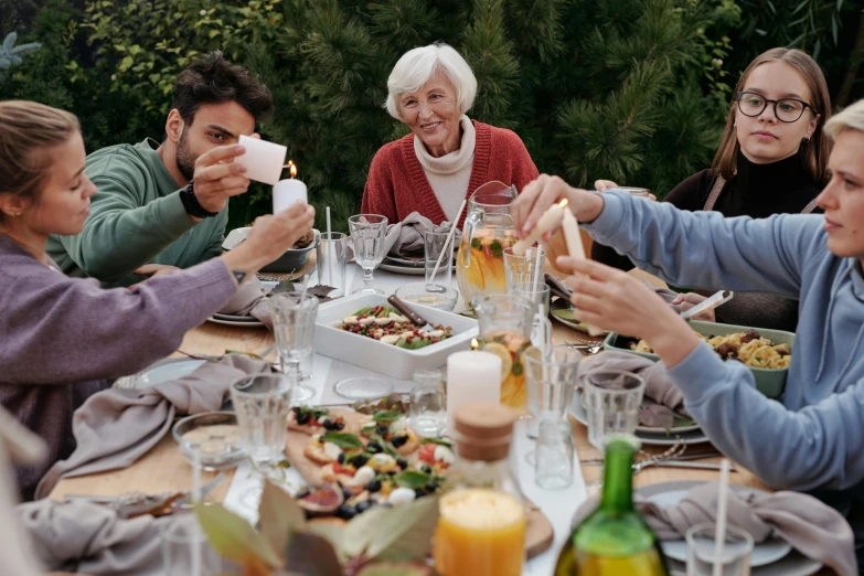 a group of people sitting around a dinner table, outdoors setting, an elderly, profile image, gourmet and crafts