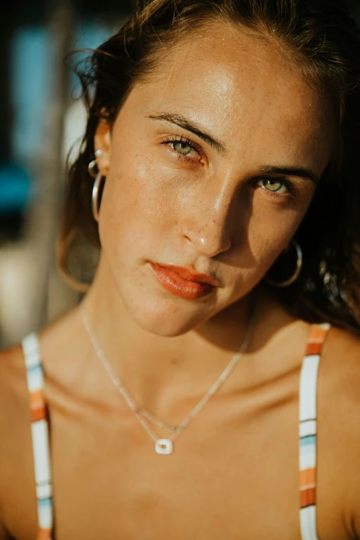 a close up of a woman with a necklace on, a picture, inspired by Elsa Bleda, trending on pexels, photorealism, tanned skin, perfect face and boy, sun overhead, brunette