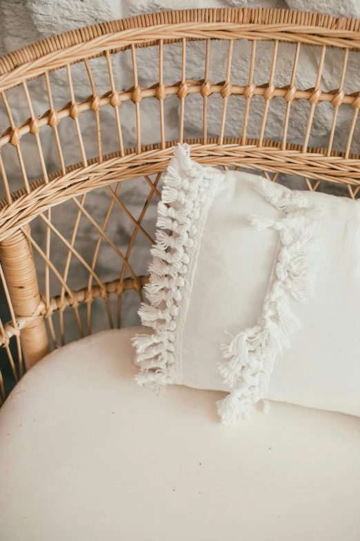 a white pillow sitting on top of a wicker chair, by Nicolette Macnamara, baroque, close-up product photo, boho, corners, vanilla