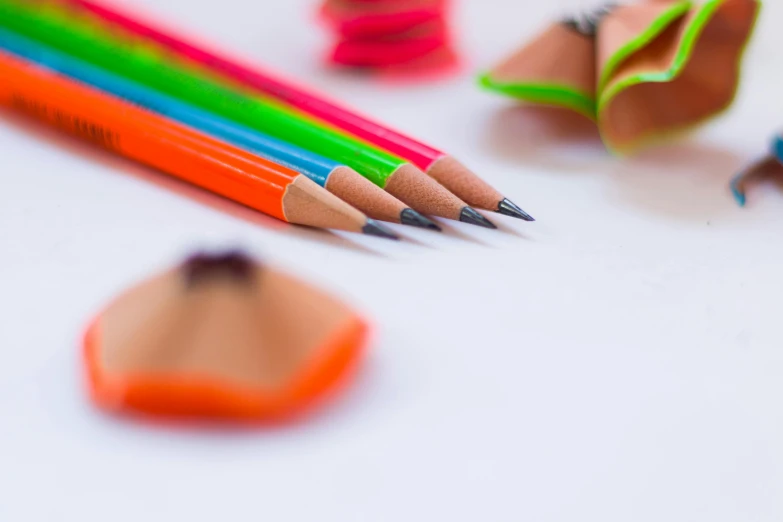 a group of colored pencils sitting on top of a table, a child's drawing, by Adam Marczyński, pexels, with fluo colored details, with a white background, sharp focus!, chartreuse and orange and cyan