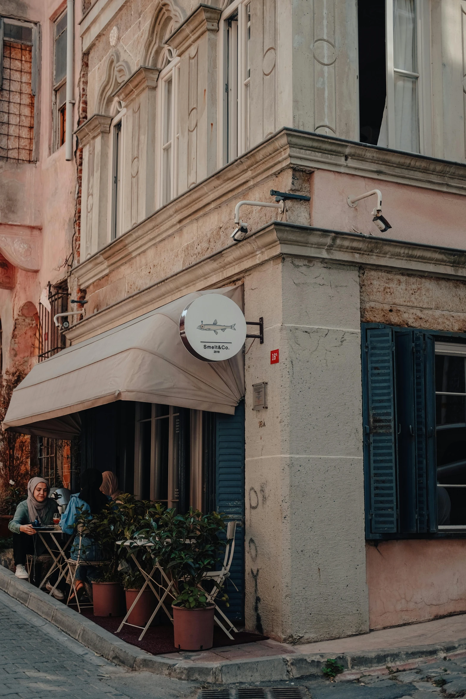 a couple of people sitting outside of a building, by Niko Henrichon, pexels contest winner, renaissance, restaurant menu photo, awnings, promo image, artwork of a building