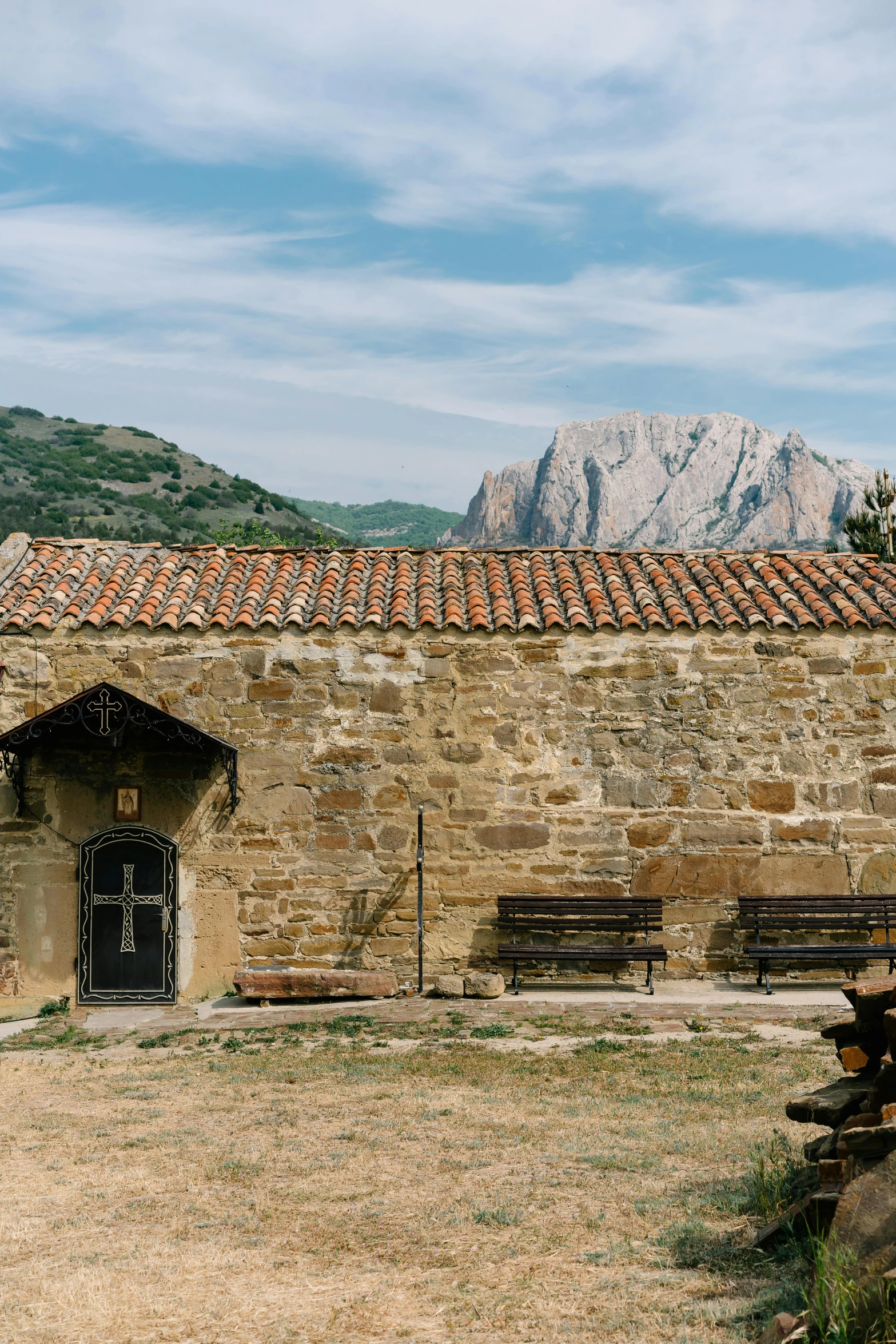 a stone building with a mountain in the background, by Carlo Carrà, romanesque, rustic setting, nomad, and, frontal shot