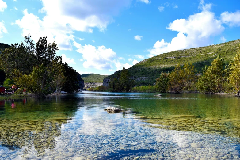 a large body of water surrounded by trees, pexels contest winner, tx, blue river in the middle, hot springs hidden cave, fishing