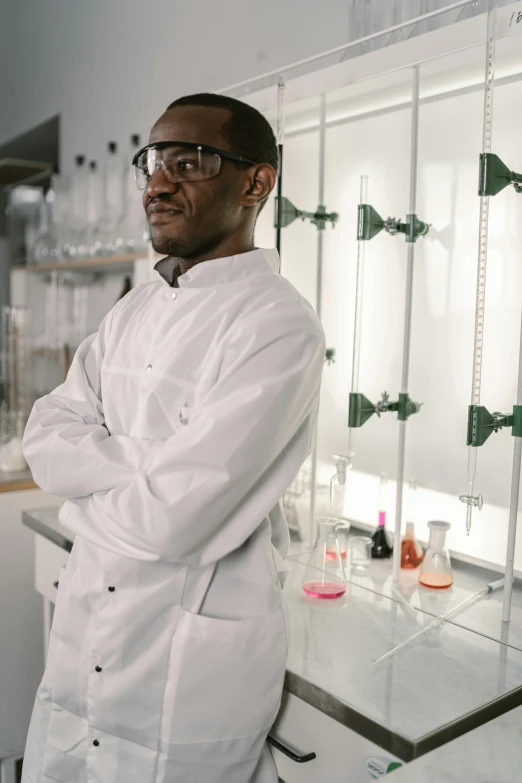 a man in a lab coat standing in front of a counter, pexels contest winner, adebanji alade, looking off into the distance, college, white uniform