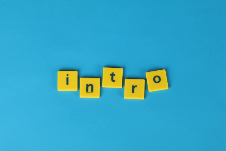 the word intro spelled with scrabbles on a blue background, an album cover, by Caro Niederer, trending on unsplash, international typographic style, yellow, tabletop role playing game, 3 - piece, inflatable