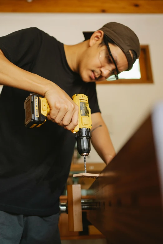 a man using a cordless drill on a piece of wood, an album cover, by Everett Warner, pexels, happening, asian male, in house, avatar image
