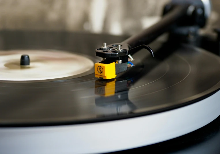 a close up of a record on a turntable, by Niko Henrichon, pexels contest winner, private press, yellow, miniature product photo, thumbnail, dynamic angled shot