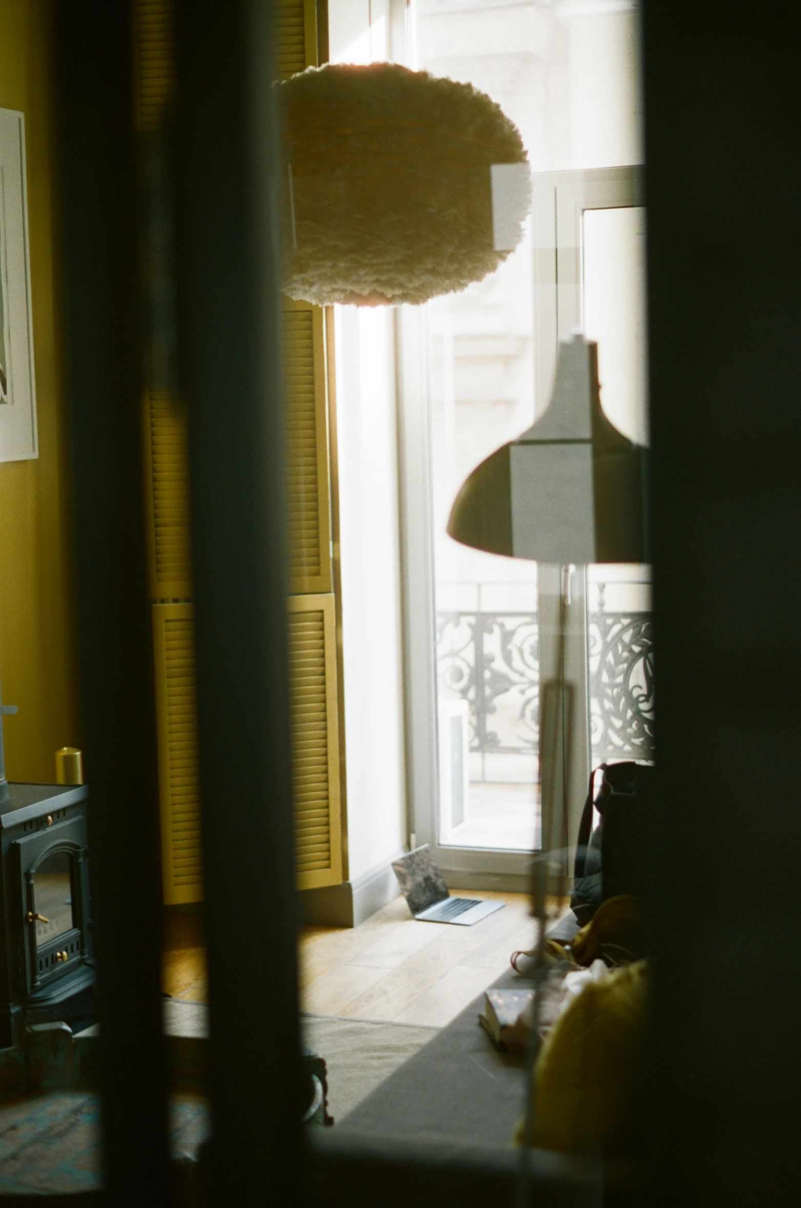 a living room filled with furniture next to a window, inspired by André Kertész, unsplash, light and space, view from behind mirror, taken with kodak portra, emerging from her lamp, medium format. soft light