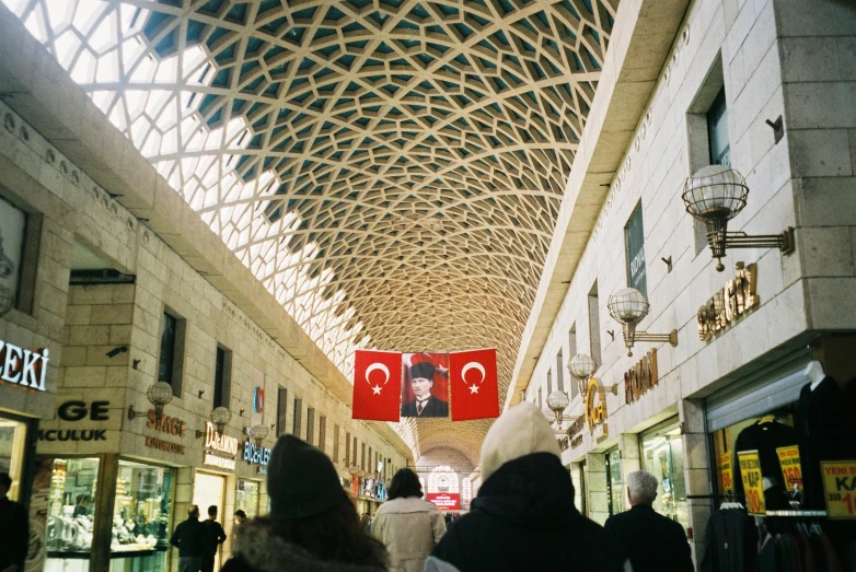 a group of people walking through a shopping mall, inspired by Osman Hamdi Bey, tumblr, square, red flags holiday, beige, 2022 photograph