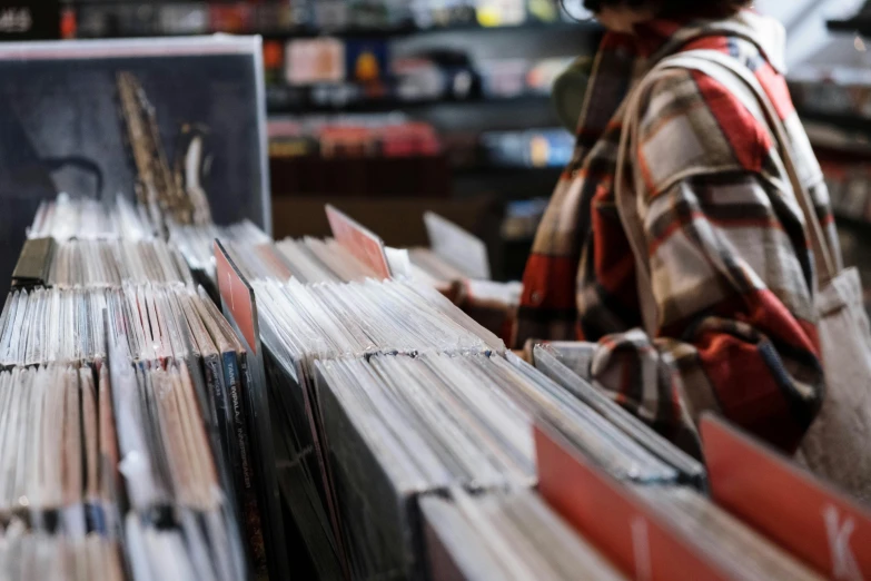 a woman looking at records in a record store, pexels, hans zimmer soundtrack, wheres wally, middle close up, piles of books