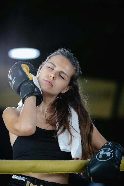 a close up of a person wearing boxing gloves, woman crying, square, black. yellow, sports setting