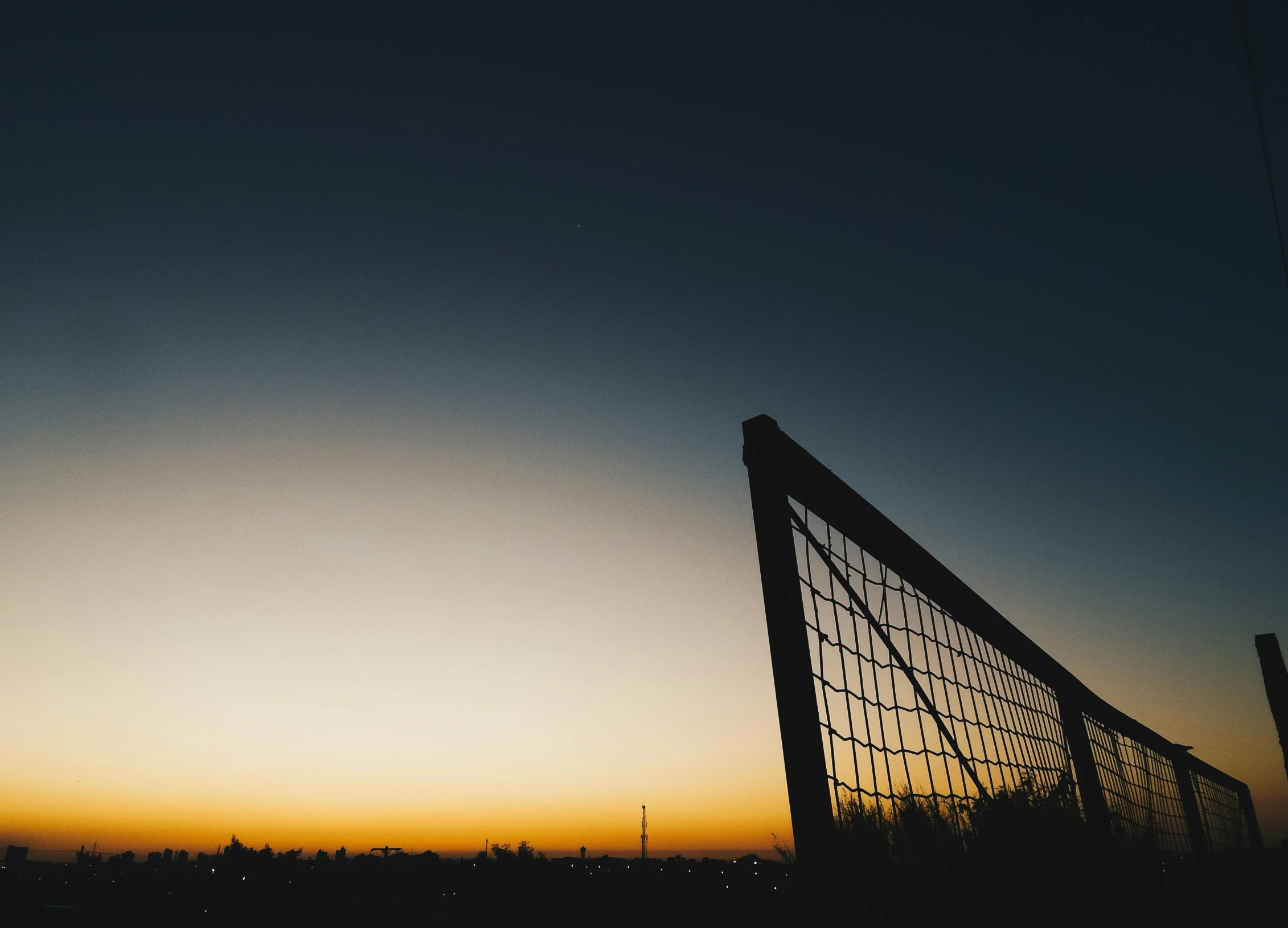 a soccer goal with the sun setting in the background, inspired by John Gibson, unsplash contest winner, twilight skyline, minimal composition, shot on hasselblad, low - angle shot