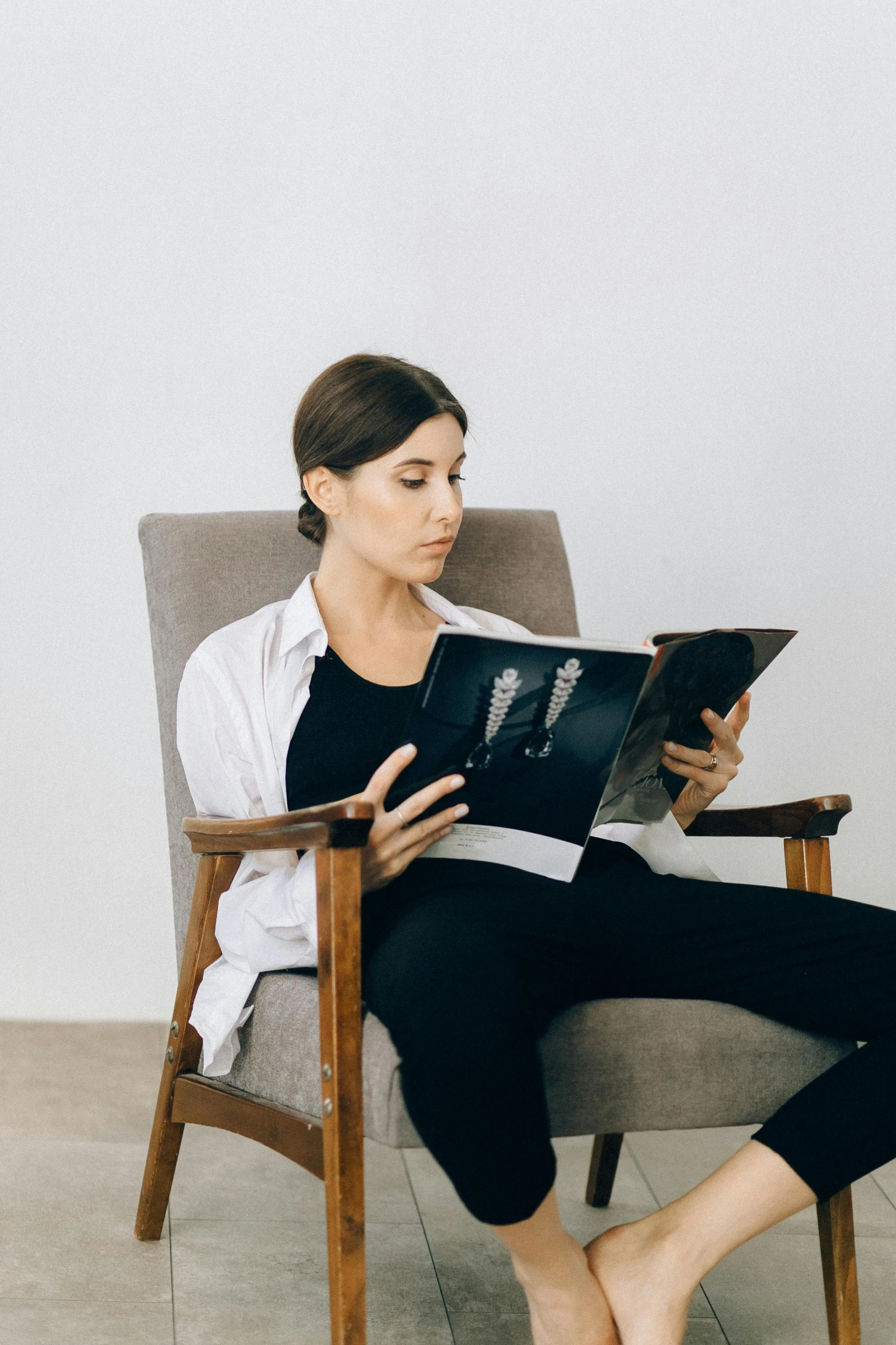 a woman sitting in a chair reading a book, an album cover, inspired by Constantin Hansen, pexels contest winner, maternity feeling, inspect in inventory image, casually dressed, anatomy