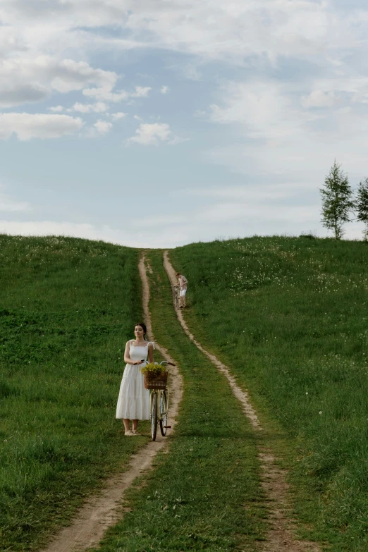 a woman walking a dog down a dirt road, inspired by Isaac Levitan, pexels contest winner, renaissance, midsommar style, wedding photo, on a green hill, russia