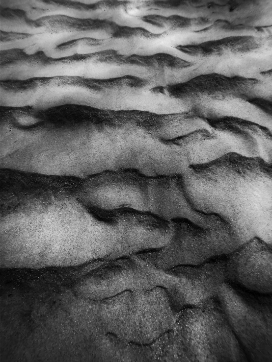 a black and white photo of sand dunes, a stipple, inspired by Edward Weston, lyrical abstraction, felt!!! texture, close-up from above, captured on iphone, folds of fabric